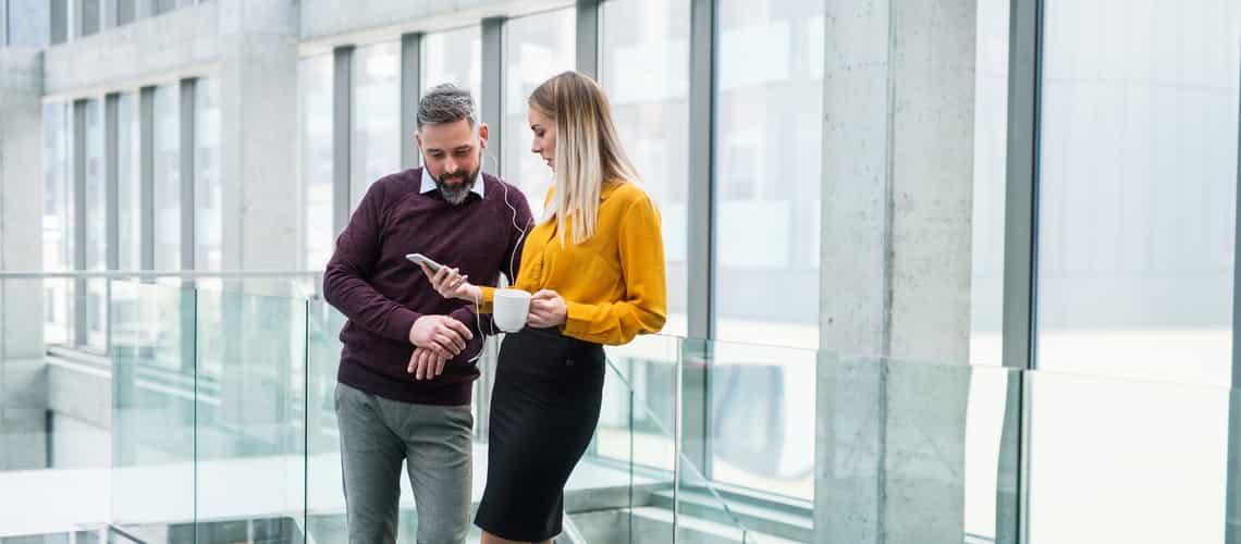 two sales professionals looking at a the status of an account on their phone, excited to see the progress they're making because of the skills they built in the prosperous account strategy training program